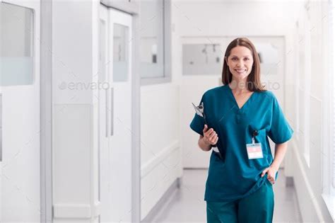 Portrait Of Smiling Female Doctor Wearing Scrubs Standing In Hospital