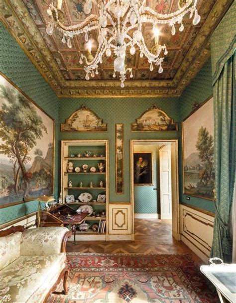 An Ornately Decorated Living Room With Green Walls And Paintings On The