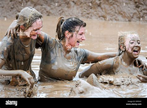 Mud Covered Women Competitors Celebrate Finishing Race Waist Deep In