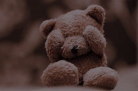 A Brown Teddy Bear Sitting On Top Of A Bed