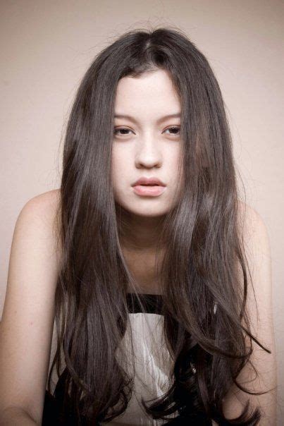 A Woman With Long Hair Is Posing For The Camera