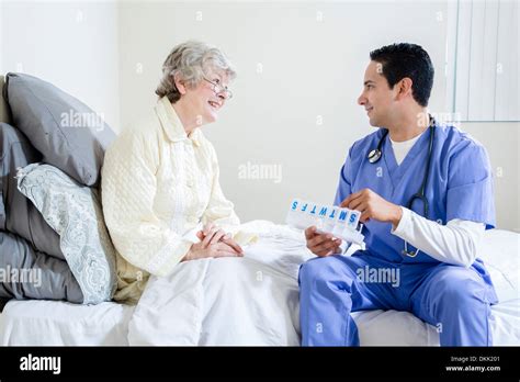 Male Nurse Helping Elderly Patient With Her Pills Stock Photo Alamy