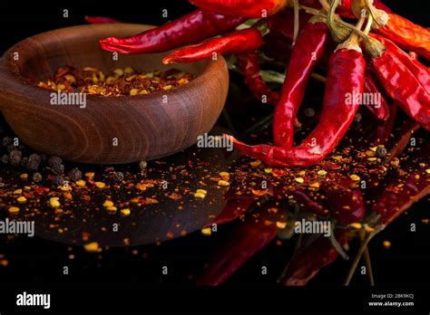 Red Chili Peppers And Chili Flakes Spices And Herbs On Black Background
