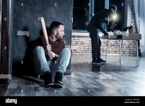Scared Man Hiding With A Stick Stock Photo Alamy