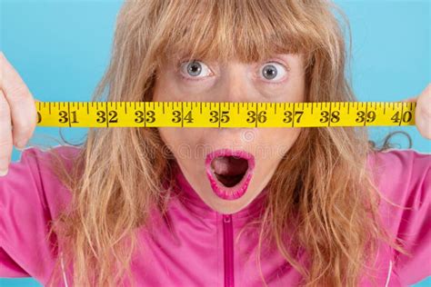 Closeup Of Astonished Woman Looking At Measuring Tape Stock Photo