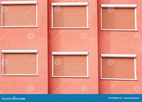 Red Building Facade With Six Closed Windows Shutters Stock Photo