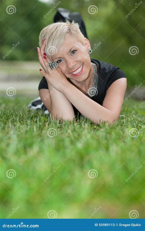 Attractive Blonde Girl Posing In Nature Lying On Grass Stock Image