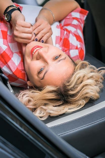 Premium Photo An Adult Blonde Woman Is Lying In The Back Seat Of A Car