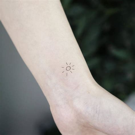 minimalist sun tattoo on the wrist
