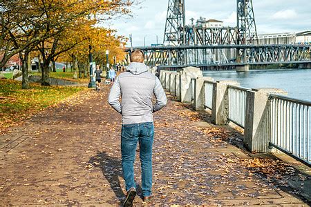 美国俄勒冈州的秋天 沿着波特兰市的河边散步的男人高清图片下载 正版图片 摄图网