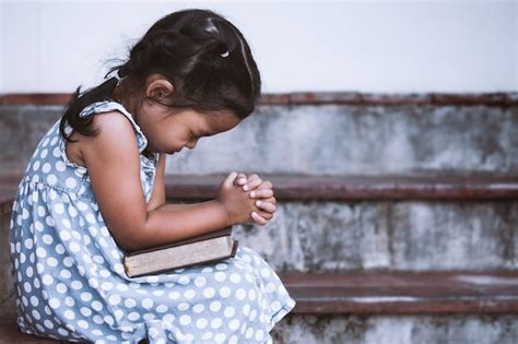 Premium Photo Little Girl Prays With A Holy Bible