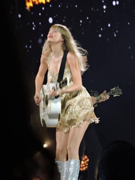 The Blond Haired Woman Is Performing On Stage With Her Guitar And