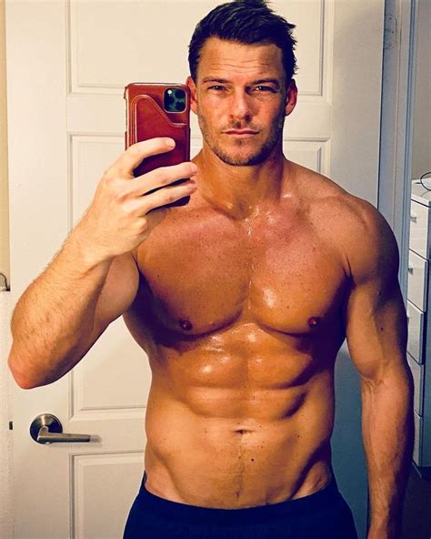 A Shirtless Man Taking A Selfie With His Cell Phone
