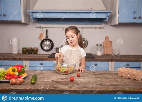 Een Kleine Dochter In De Keuken Mengt Salade Met Een Grote