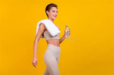 profile side view portrait of attractive slender cheerful girl holding water going visit gym