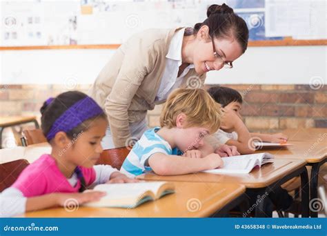Pretty Teacher Helping Pupil In Classroom Stock Photo Image Of People