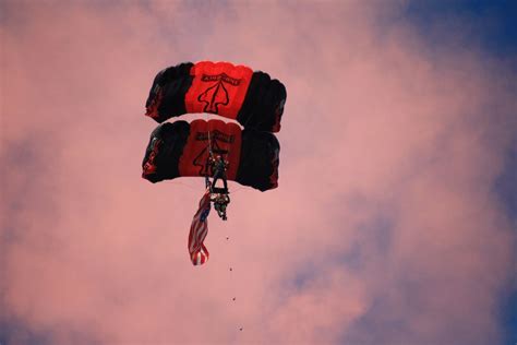 Two People Parachuting From The Sky With The American Flag Attached To