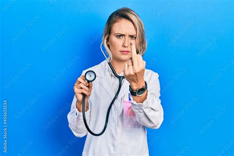 Beautiful Young Blonde Doctor Woman Holding Stethoscope Showing Middle