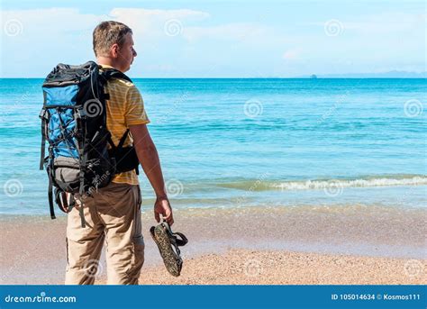 Tourist With A Backpack Spends Vacation On The Beach Stock Photo