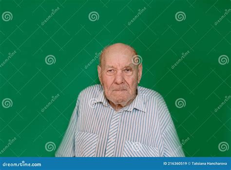 A Large Portrait Of An Old Man With A Serious Look On An Isolated Green