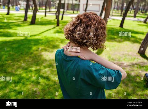 Redhead Woman Wearing Green Tee From Back Having Neck Or Shoulder Pain