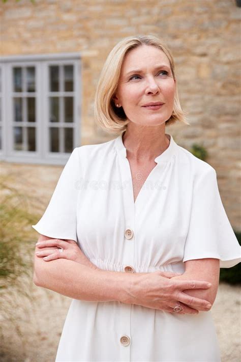 Portrait Of Mature Woman Standing Outside Front Door Of Home Stock Photo Image Of Senior