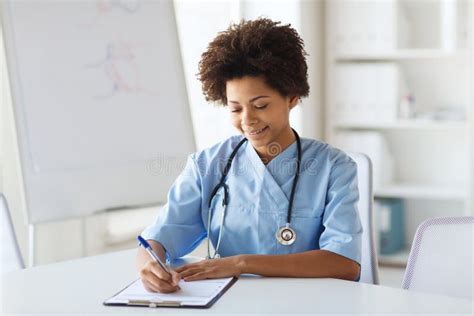 Happy Female Doctor Or Nurse Writing To Clipboard Stock Image Image