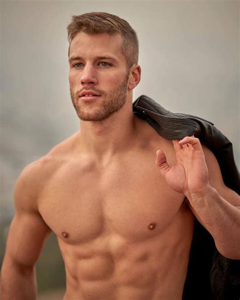A Man With No Shirt On Is Holding His Jacket Over His Shoulder
