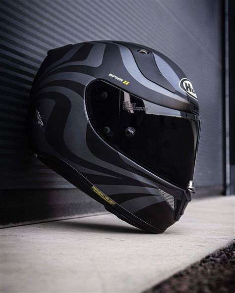 A Motorcycle Helmet Sitting On The Ground Next To A Wall