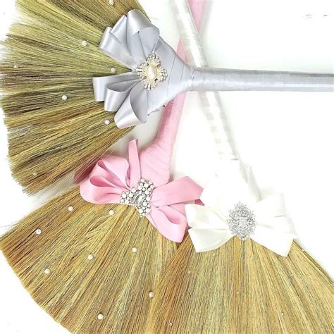 Two Brooms With Bows On Them Sitting Next To Each Other In Front Of A