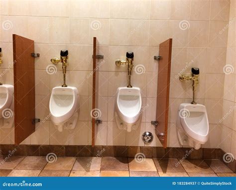 Urinal In Mens Public Restroom Bathroom With Luxury Gold Plumbing Stock