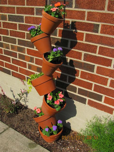 Several Flower Pots Are Arranged On The Side Of A Brick Wall To Form A