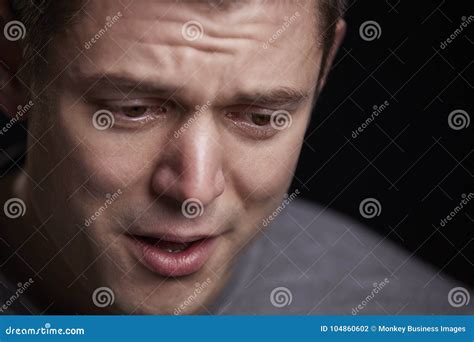 Close Up Portrait Of Crying Young White Man Looking Down Stock Photo
