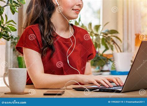 Freelancea Young Happy Caucasian Woman Typing On A Laptop With Headphones In Her Earshome