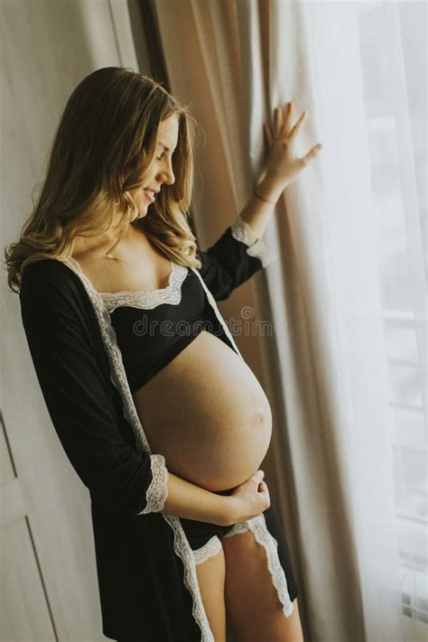 Pregnant Woman Wearing Lingerie And Posing In The Room Stock Image