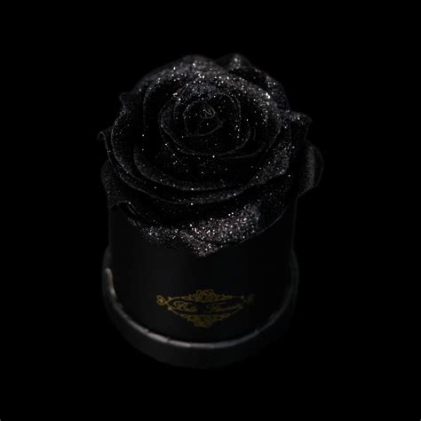 A Black Hat With Glitter On It And A Rose In The Center Against A Dark