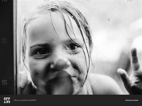Portrait Of Young Girl With Face Pressed Against Glass Stock Photo Offset