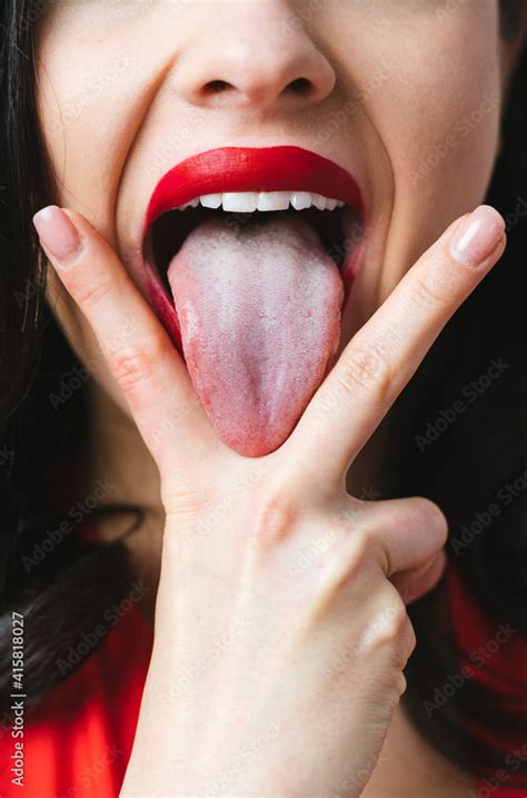 Image Of A Woman Sticking Her Tongue Out Between The Fingers Stock Foto Adobe Stock
