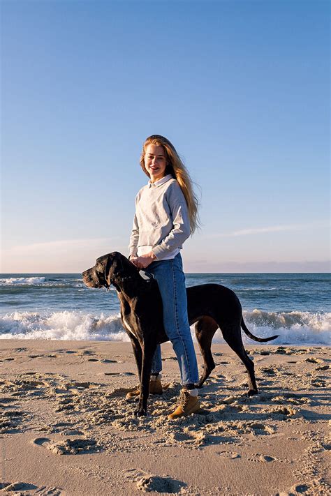 Lady Standing Atop Her Big Black Dog By Stocksy Contributor Danil