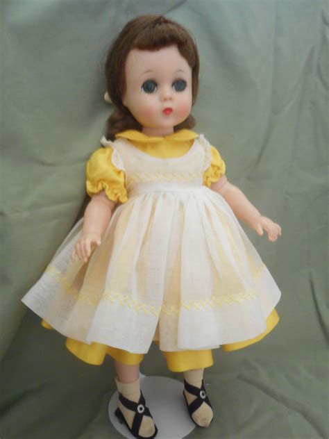 The Doll Is Wearing A Yellow Dress And Black Shoes