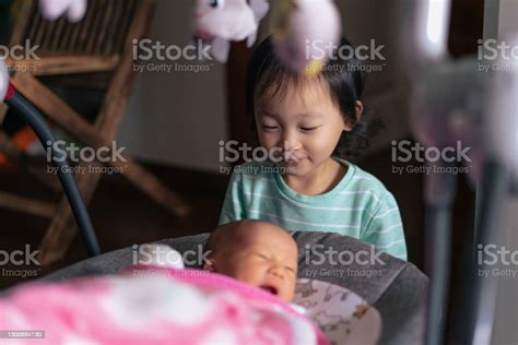 Asian Sister Showing Her Gentle Side Welcoming Her New Brother Stock