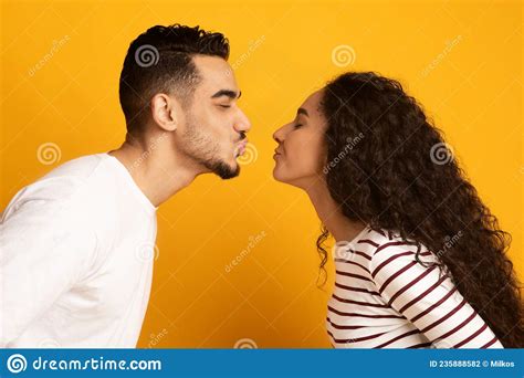 Cheerful Young Arab Couple Reaching Each Other With Lips Ready To Kiss