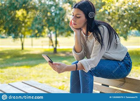 Worried Girl Waiting For A Phone Call And Looking At Mobile Phone Stock