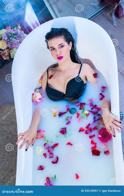 Brunette Woman Relaxing In Hot Milk Bath With Flowers Stock Image
