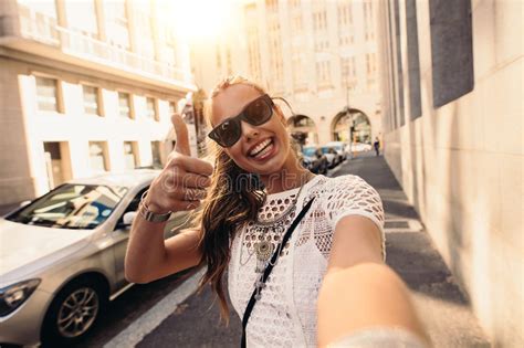 Tourist Taking Selfie In A Street Surrounded By Buildings Stock Image