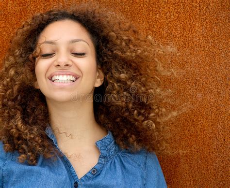 Portrait Of A Beautiful Young Woman Smiling With Curly Hair Stock Photo