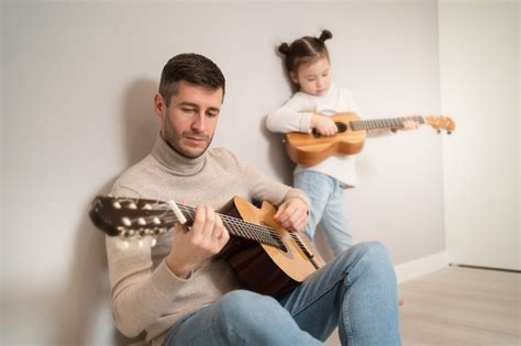 Papá Toca La Guitarra Con Su Hija El Niño Aprende A Tocar Un