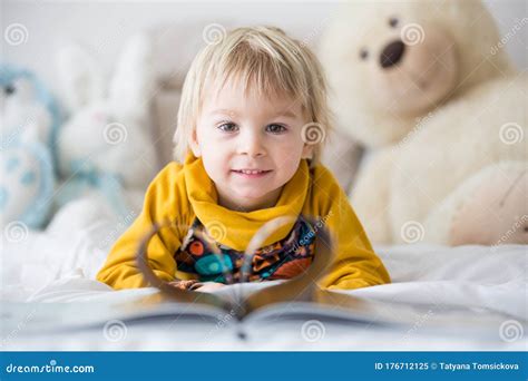 Beautiful Child Toddler Boy Reading Book And Playing With It