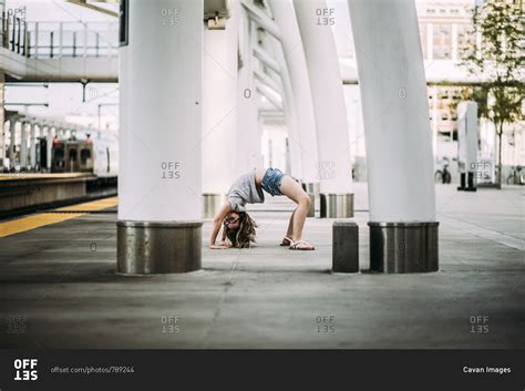 Side View Of Girl Bending Over Backwards At Railroad Station Platform