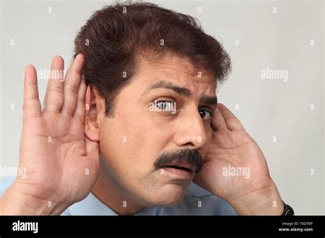 Portrait Of A Businessman Cupping Hands To Ears Stock Photo Alamy